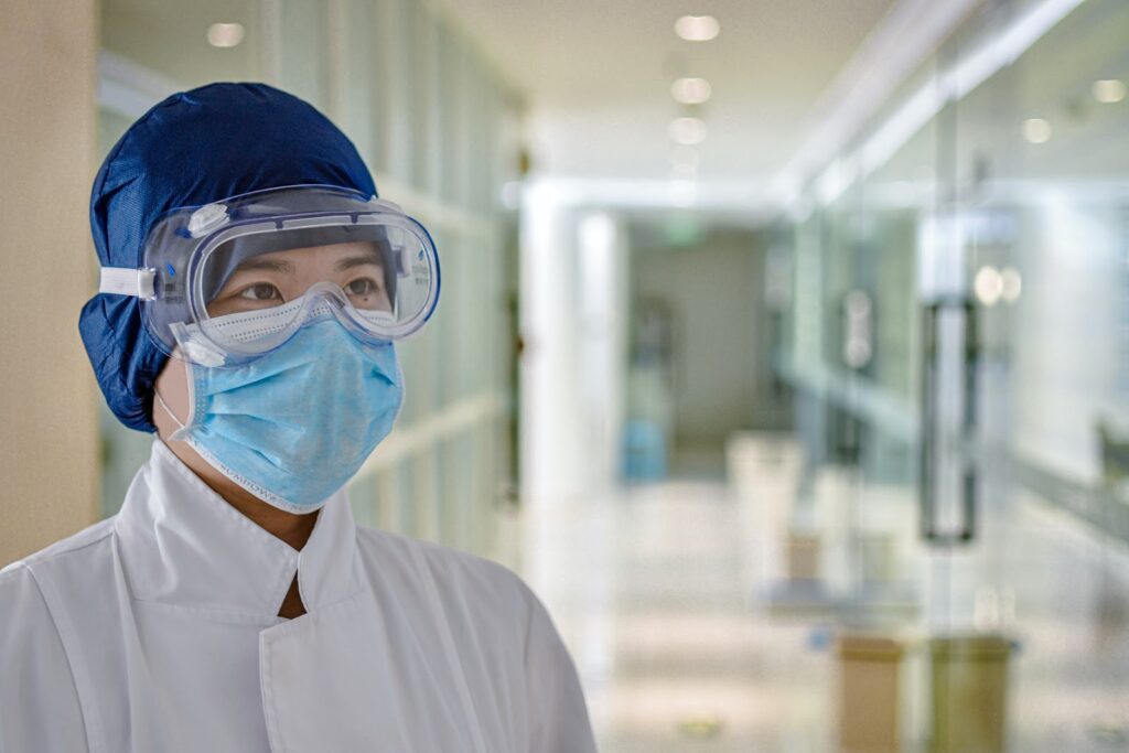 woman in goggles and mask in hospital coronavirus waste management