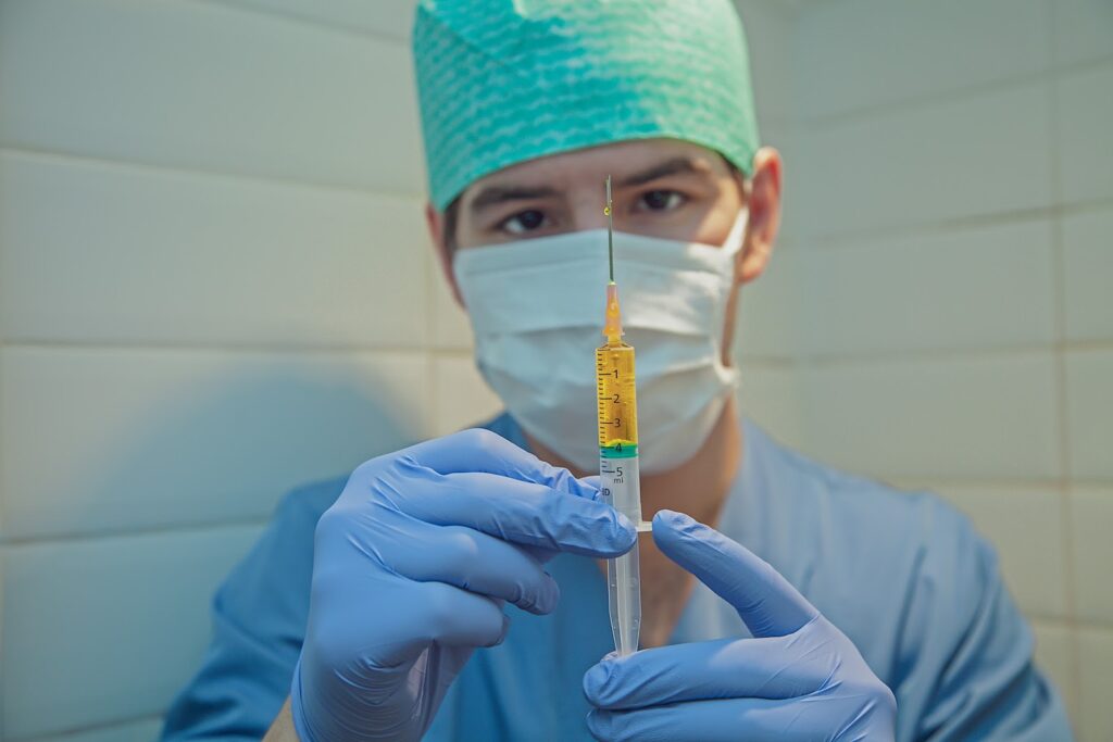 nurse with mask holding needle syringe OSHA